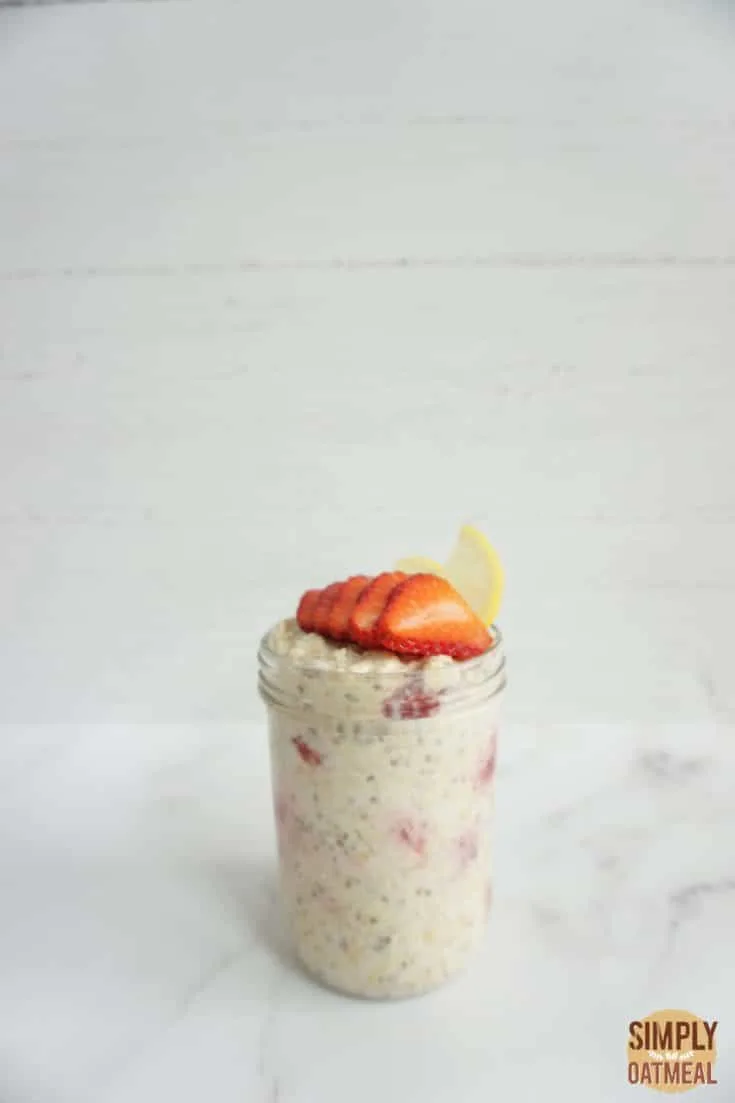 Single serving of lemon strawberry overnight oats in a mason jar with sliced strawberries on top