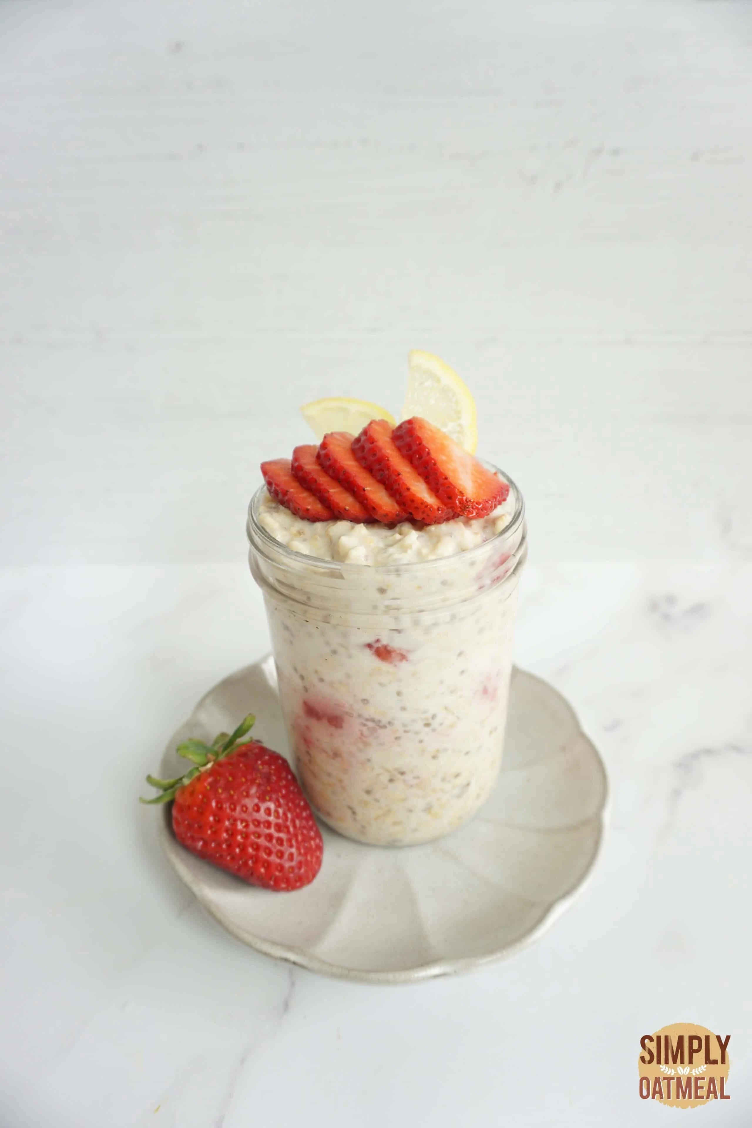 Lemon strawberry overnight oats in a mason jar with wild strawberries on the side