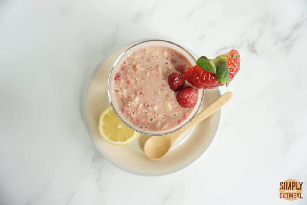Pink lemonade overnight oats served in a mason jar garnished with raspberries and strawberries