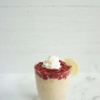 Single serving of raspberry lemonade overnight oats in a glass cup with raspberry chia jam on top