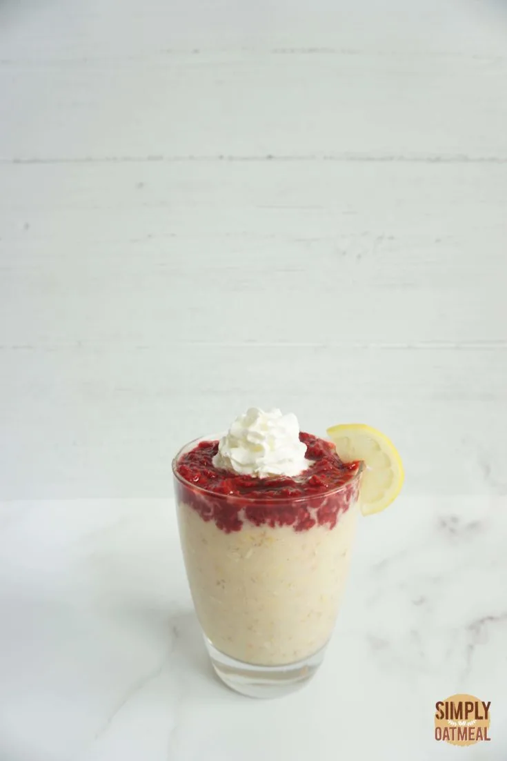 Single serving of raspberry lemonade overnight oats in a glass cup with raspberry chia jam on top
