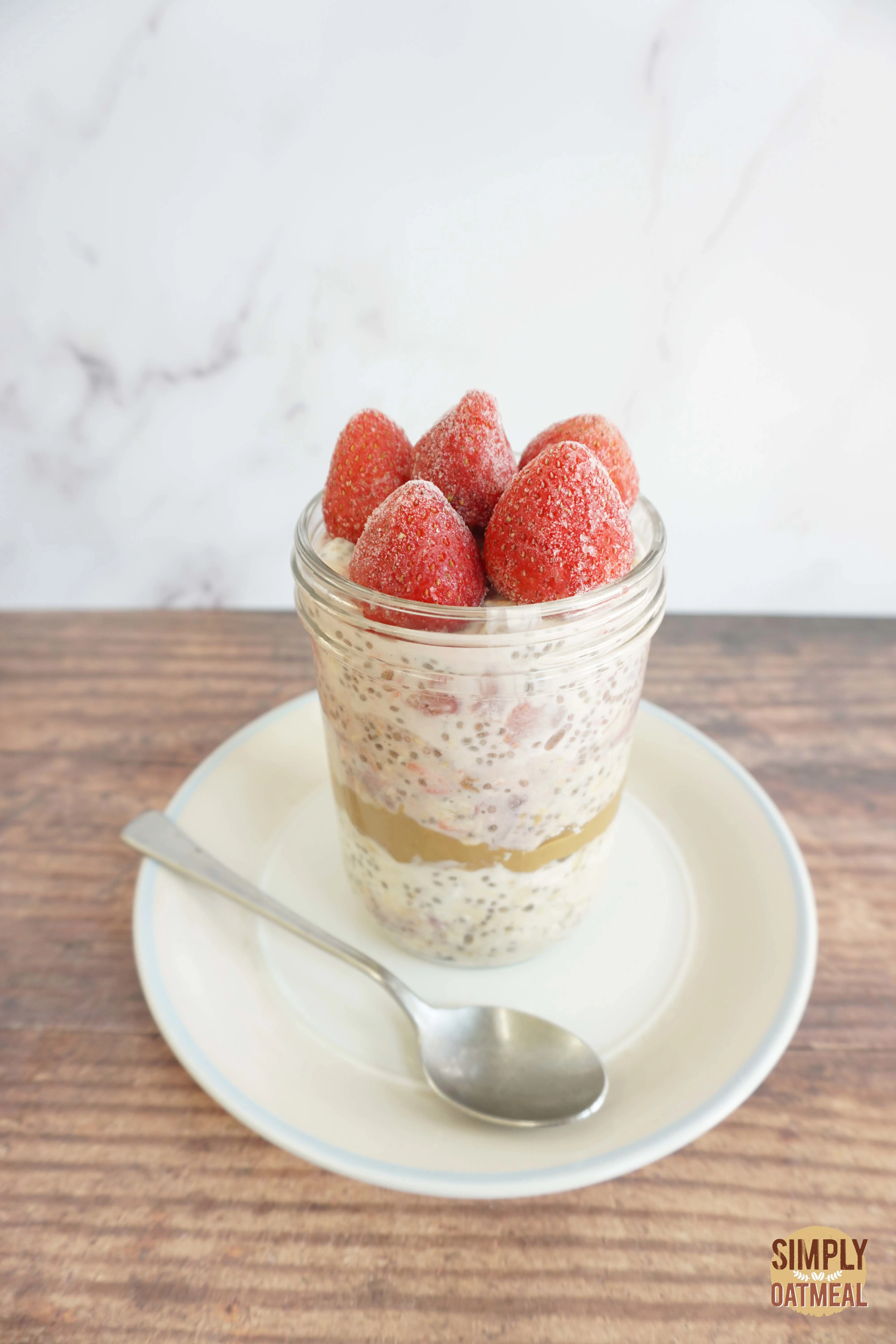 Strawberry chia overnight oats in a mason jar garnished with wild strawberries.
