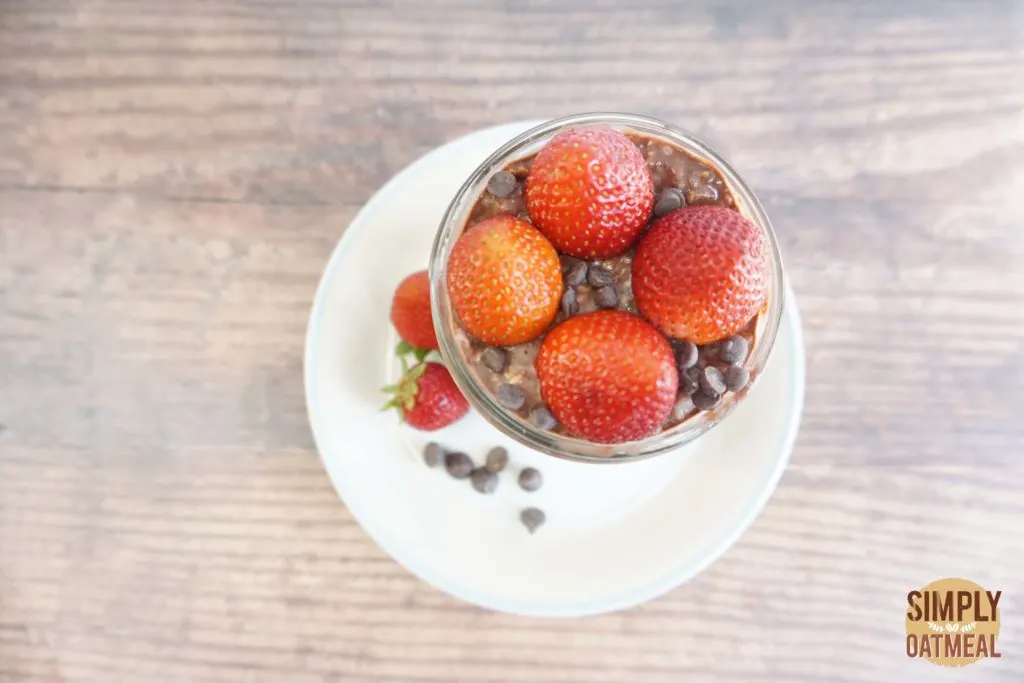 Serving of strawberry chocolate overnight oats in a glass cup Serving of strawberry chocolate overnight oats in a glass cup topped with wild strawberries and mini chocolate chips