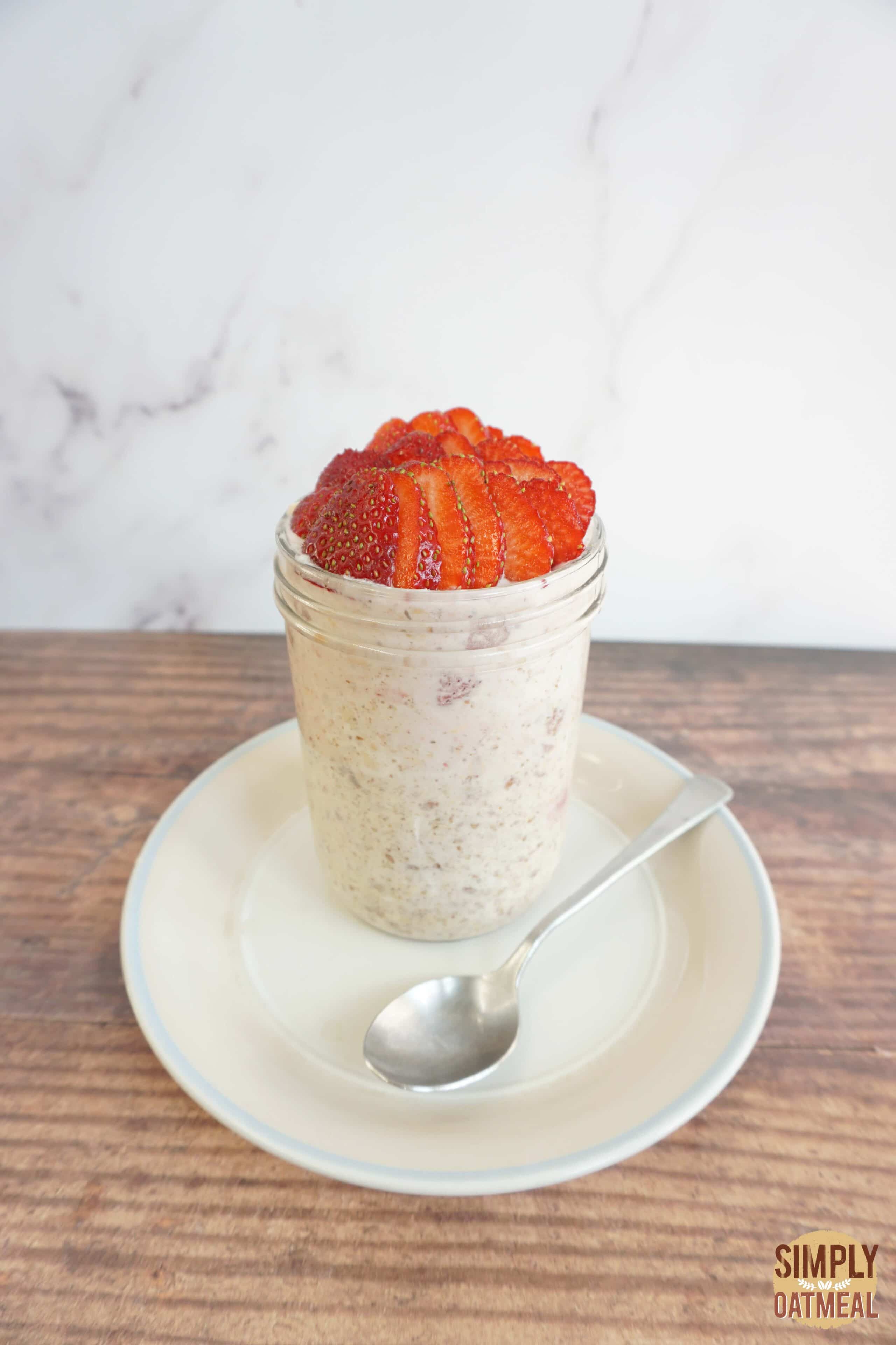 Strawberry cream cheese overnight oats in a mason jar with wild strawberries on top