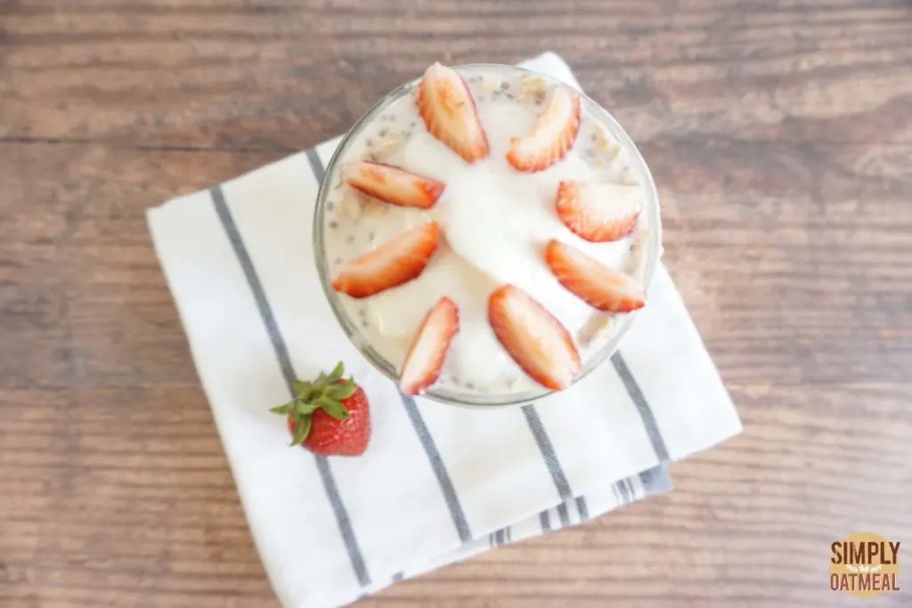 Serving of strawberry vanilla overnight oats in a glass cup Serving of strawberry vanilla overnight oats in a glass cup topped with sliced strawberries and vanilla whipped cream