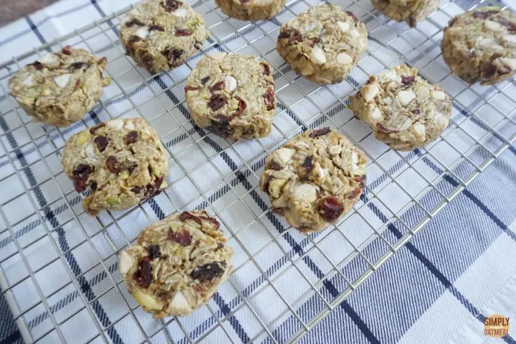 Hot white chocolate cherry oatmeal cookies cooling off on a wire rack