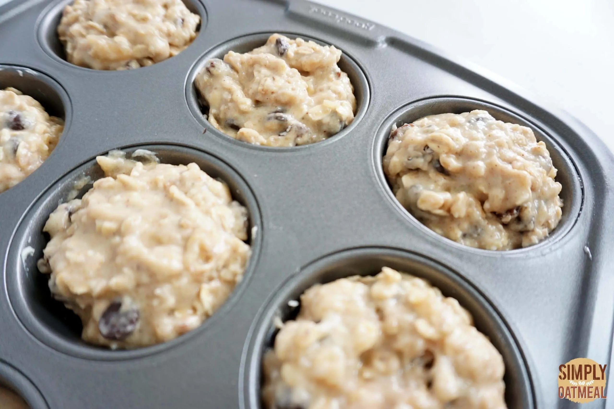 Baked applesauce oatmeal muffins in a muffin pan