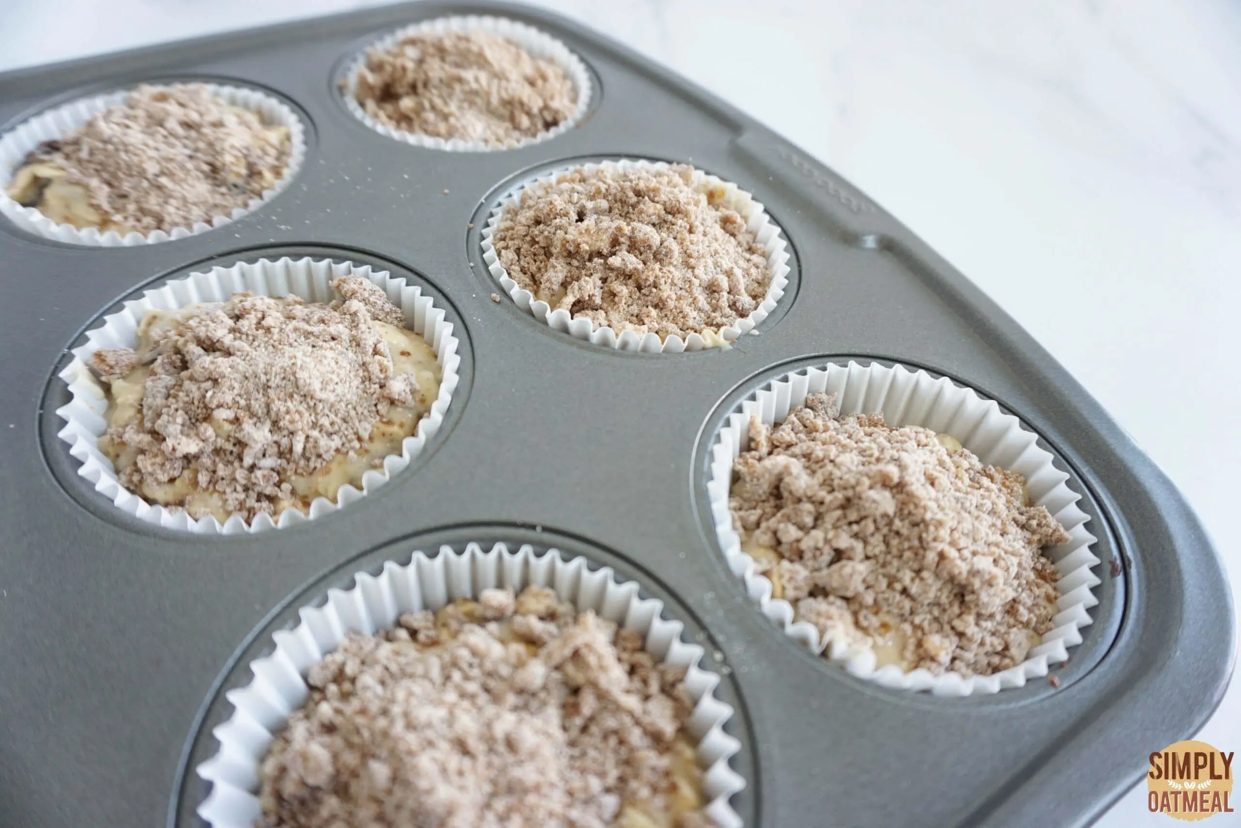 Baked cinnamon streusel oatmeal muffins in a muffin pan