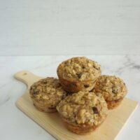 Fresh baked applesauce oatmeal muffins on a wooden plate