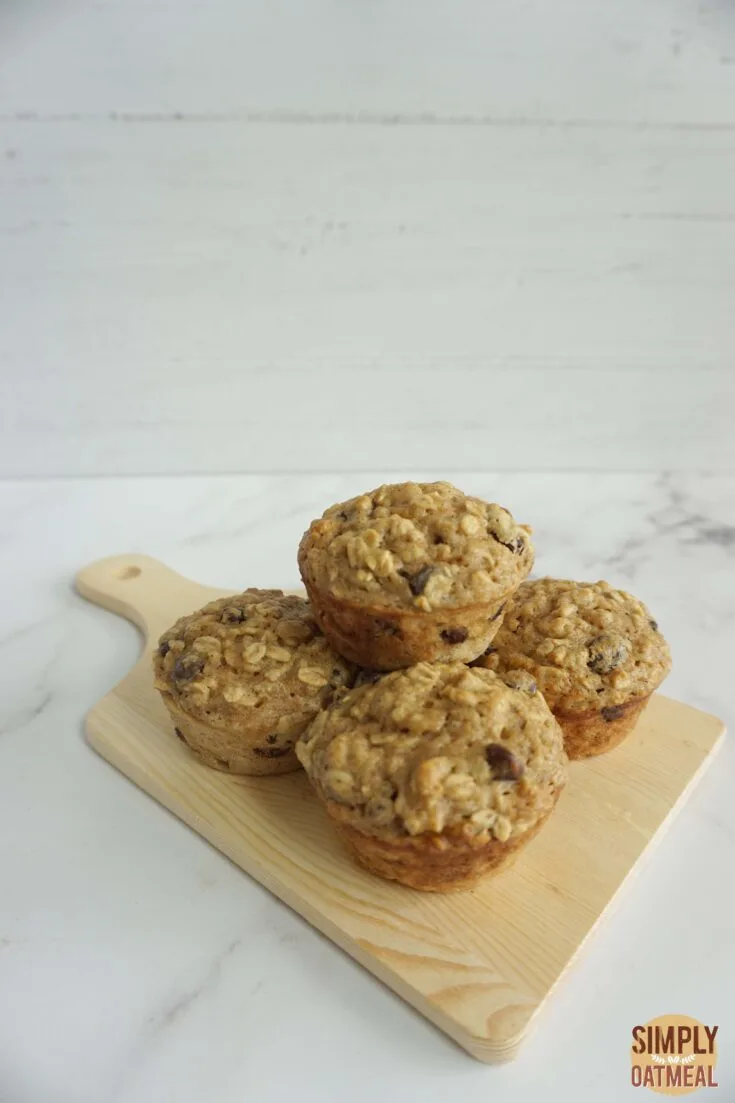 Fresh baked applesauce oatmeal muffins on a wooden plate