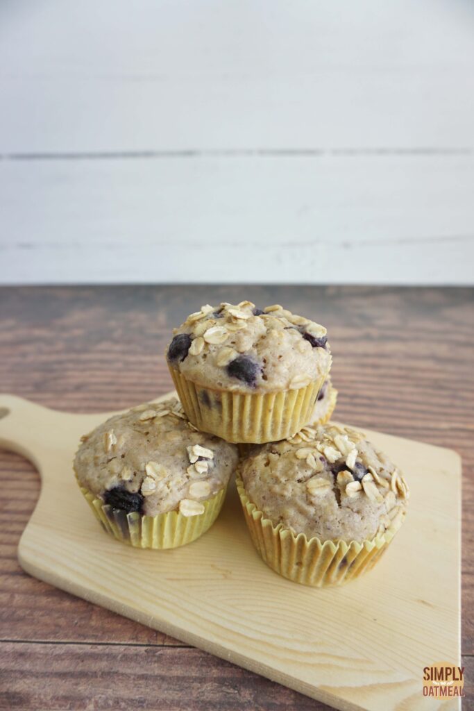 Fresh baked blueberry lemon oatmeal muffins on a wood plate