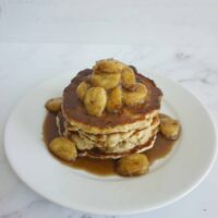 Banana butterscotch oatmeal pancakes stacked on a plate