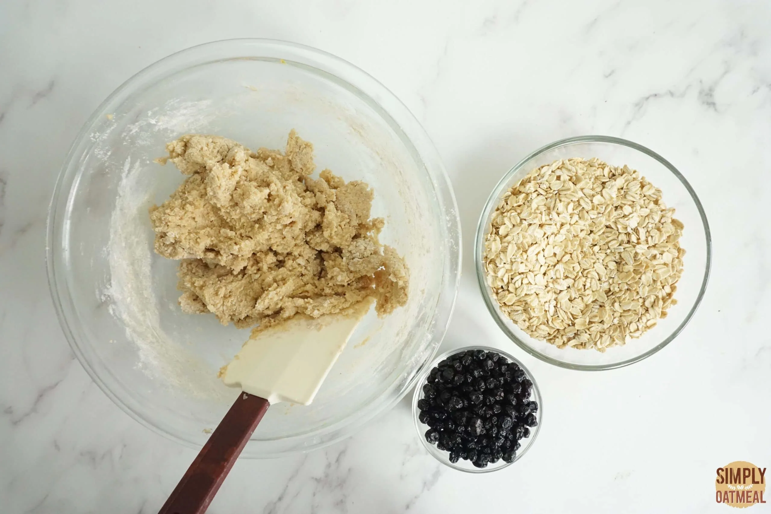 Fold oats and dried blueberries into the raw cookie dough.