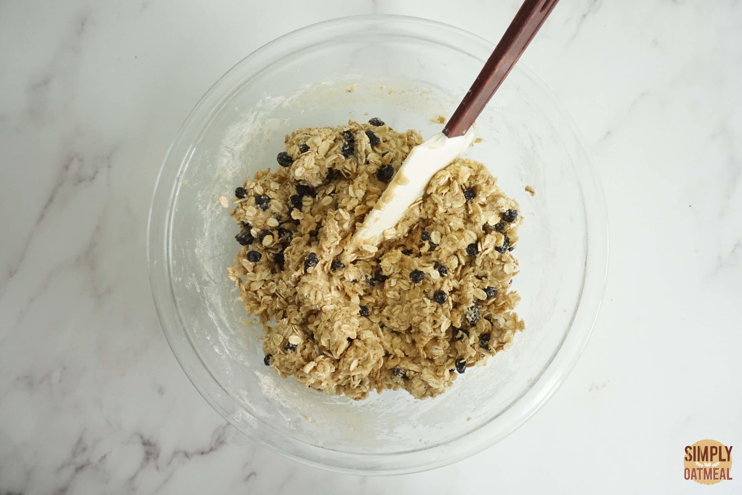 Raw blueberry lemon oatmeal cookie dough in a mixing bowl.