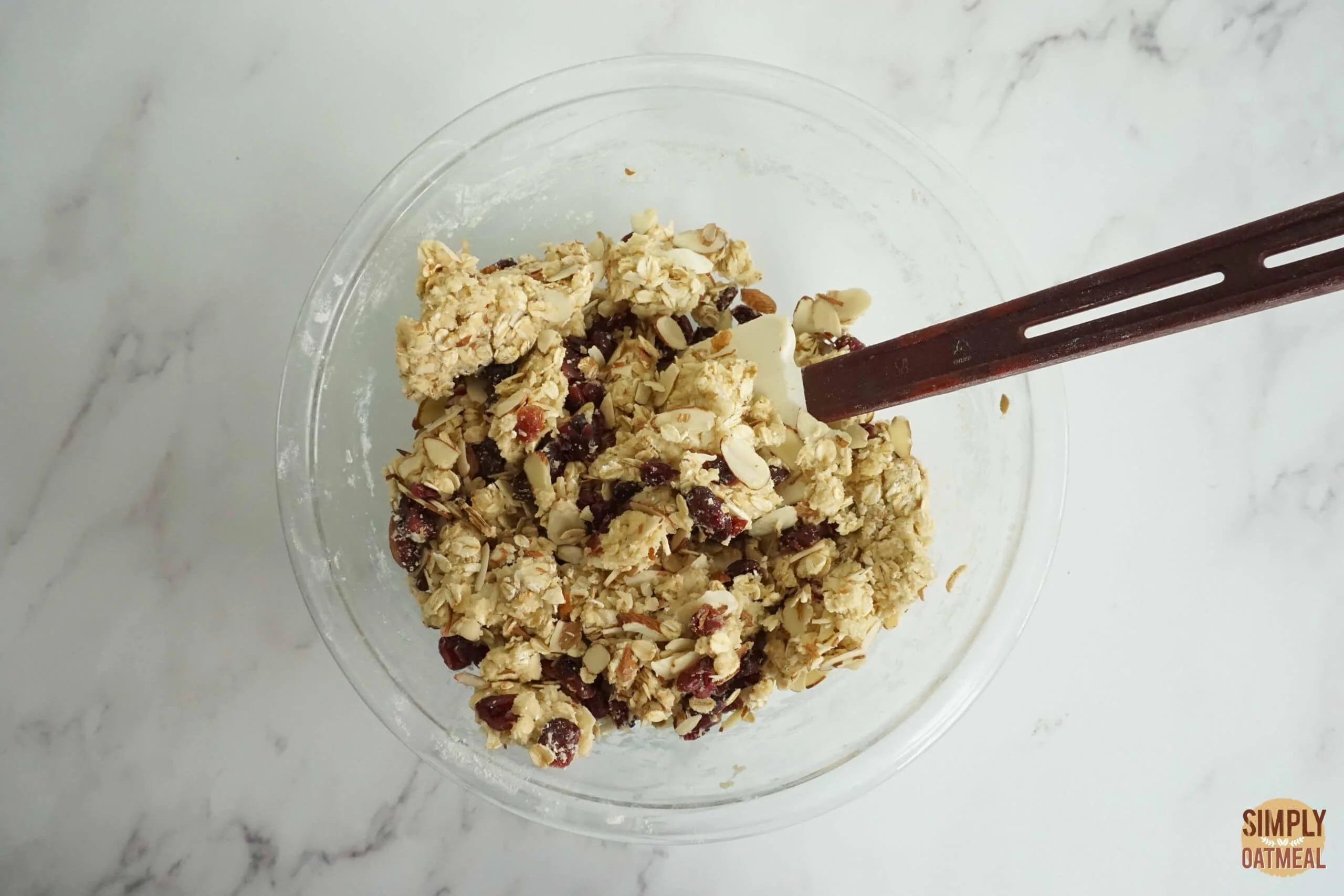 Raw cranberry almond oatmeal cookie dough in a mixing bowl.
