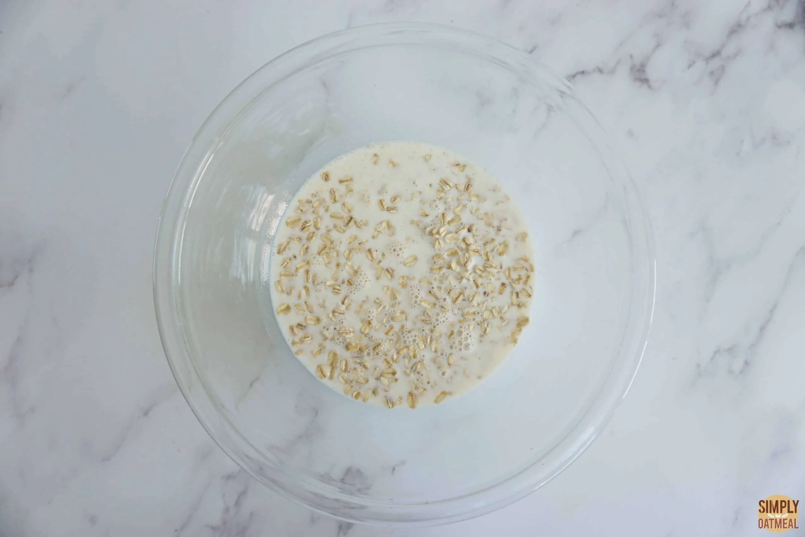 Soaked oats in a mixing bowl to make banana butterscotch oatmeal pancakes