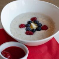 Cooked Irish oats is a white bowl with fresh berries on top