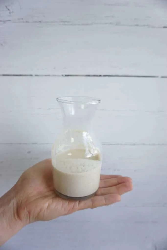 Hand holding a cup of oat creamer Hand holding a cup of oat creamer