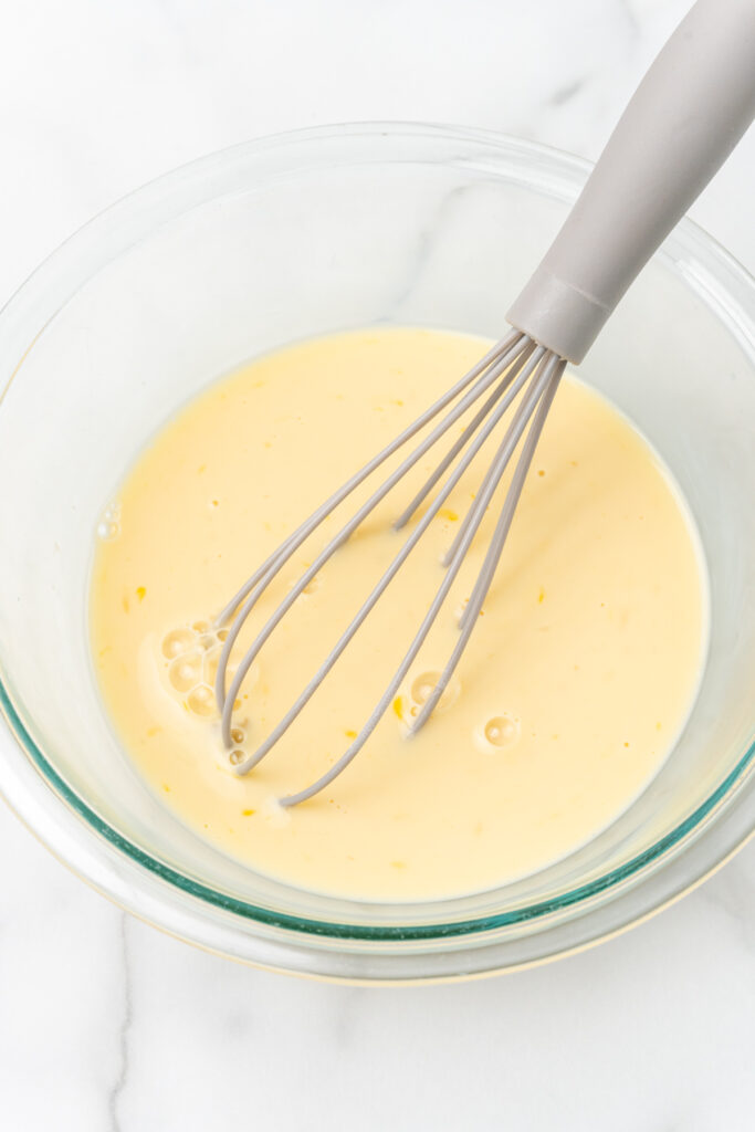 Whisk with yellow batter.